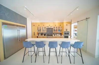 a kitchen with a large island with blue bar stools at Luxury villa with Private beach access in Sosúa