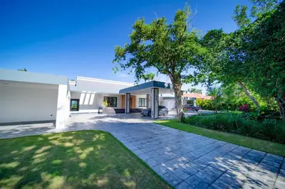 a house with a driveway and a tree at Luxury villa with Private beach access in Sosúa