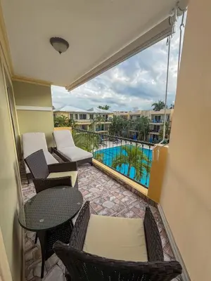 a balcony with a table and chairs and a pool at Garden Condos APT 35 - Affordable 1BR APT in Sosua in Sosúa