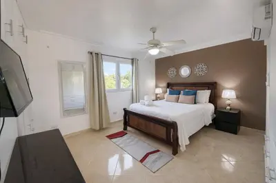 a bedroom with a large bed and a window at Garden Condos APT 35 - Affordable 1BR APT in Sosua in Sosúa