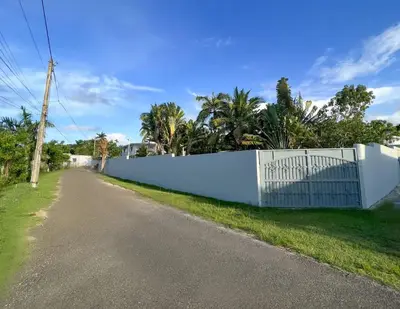 a white fence on the side of a road at COZY 7BR Villa BIG POOL Close to beach in Sosúa
