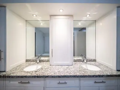 a bathroom with two sinks and two mirrors at 4BR Penthouse with Rooftop Pool in Sosua strip in Sosúa
