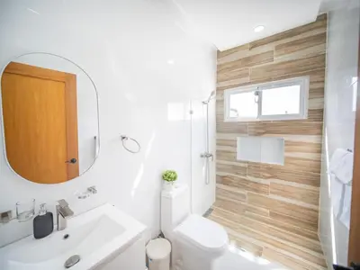 a bathroom with a toilet and a sink and a mirror at First class 4BR KING SIZE Villa in Sosua town in Sosúa