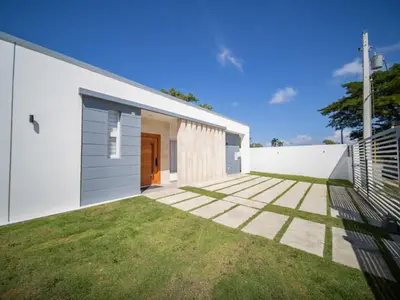 a white house with a lawn in front of it at First class 4BR KING SIZE Villa in Sosua town in Sosúa