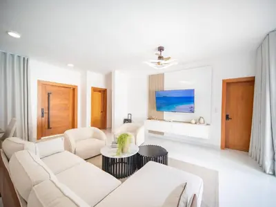 a white living room with a couch and a tv at First class 4BR KING SIZE Villa in Sosua town in Sosúa