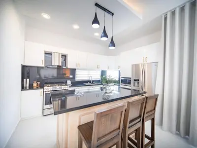 a kitchen with a counter and two chairs in it at First class 4BR KING SIZE Villa in Sosua town in Sosúa