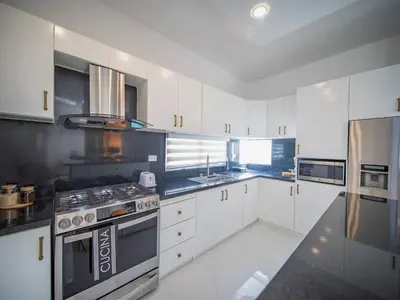 a kitchen with white cabinets and a stove top oven at First class 4BR KING SIZE Villa in Sosua town in Sosúa