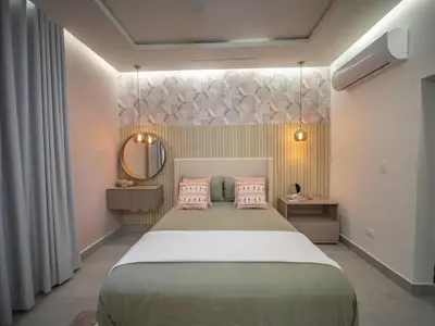 a bedroom with a bed with pink pillows and a mirror at Stylish Luxury Villa in Sosua- 5BR Suites in Sosúa