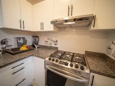 a kitchen with a stainless steel stove and white cabinets at Stylish Luxury Villa in Sosua- 5BR Suites in Sosúa