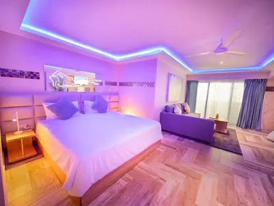 a purple bedroom with a large bed and a couch at North Coast Luxury Villa in Sosua - 6BR Suites in Sosúa
