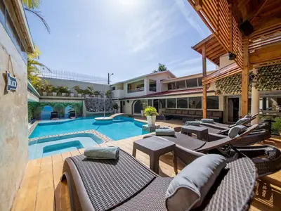 a house with a swimming pool and some patio furniture at North Coast Luxury Villa in Sosua - 6BR Suites in Sosúa