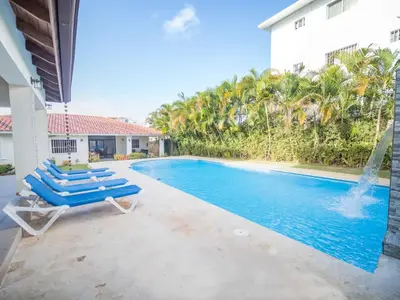 a swimming pool with blue lounge chairs and a house at Modern 5BR Private Villa in Sosua center in Sosúa