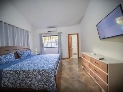 a bedroom with a bed and a flat screen tv at Modern 5BR Private Villa in Sosua center in Sosúa