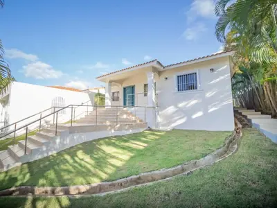 a white house with stairs and a grass yard at Modern 5BR Private Villa in Sosua center in Sosúa