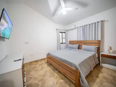 a bedroom with a bed and a television in it at Modern 5BR Private Villa in Sosua center in Sosúa