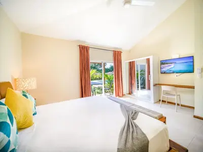 a bedroom with a bed and a desk and a window at Sun and Soul Caribbean 9BR Villa in Sosua in Sosúa