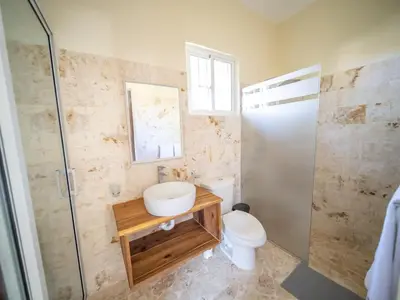 a bathroom with a toilet and a sink and a shower at Sun and Soul Caribbean 9BR Villa in Sosua in Sosúa