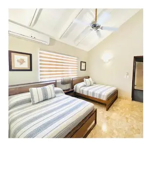 a bedroom with two beds and a ceiling at Casa De Campo Beautiful Villa with AC in the all house steps from the beach in La Romana