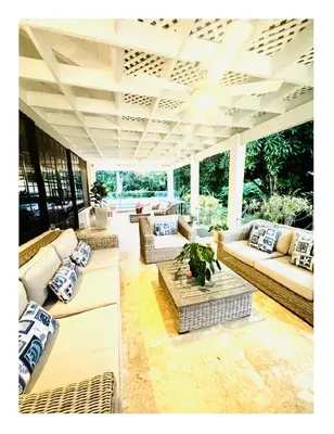 an outdoor patio with couches and a table at Casa De Campo Beautiful Villa with AC in the all house steps from the beach in La Romana