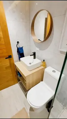 a bathroom with a toilet and a sink and a mirror at Caribbean Dream Bayahibe Seaside 3Br Penthouse in Bayahibe