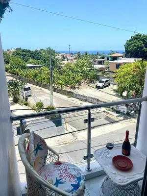 a balcony with a table and a bottle of wine at Royal Terrace Queen 1 in San Felipe de Puerto Plata