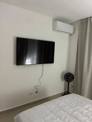 a bedroom with a flat screen tv on the wall at Residential hammock 2, next to the brewery in Concepción de La Vega
