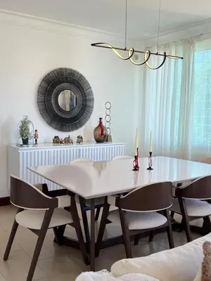 a dining room with a white table and chairs at Moderno y Acogedor Apartamento detrás del Homs in Santiago de los Caballeros