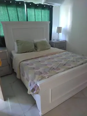 a bedroom with a large white bed with green curtains at A space designed for you in San Cristóbal