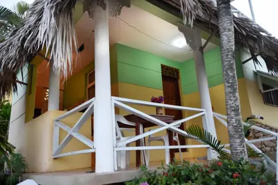 a colorful house with palm trees in front of it at Las Mariposas in Las Galeras