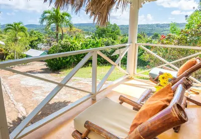a rocking chair on a porch with a view of the ocean at Las Mariposas in Las Galeras