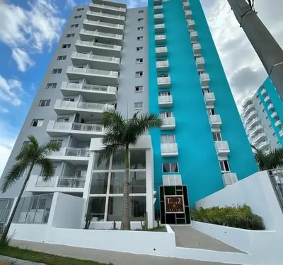 a building with palm trees in front of it at Apartamento paseo del bosque in Santo Domingo