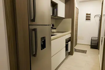 a kitchen with a stainless steel refrigerator in a room at Condominio de lujo Salida a playa Estilo Resort Muchas comodidades: 6 piscinas/TV/aire acondicionado in Punta Cana