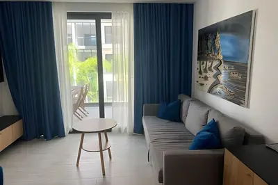 a living room with a couch and a table at Condominio de lujo Salida a playa Estilo Resort Muchas comodidades: 6 piscinas/TV/aire acondicionado in Punta Cana