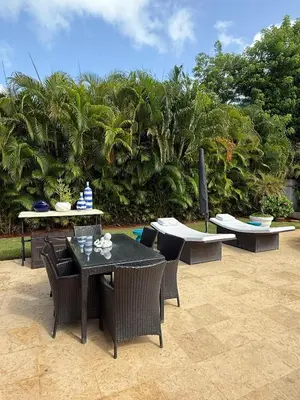 a patio with a table and chairs and trees at Hermosa y acogedora Villa en Casa de Campo in La Romana
