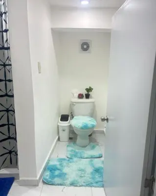 a bathroom with a toilet and a blue rug at Aparta estudio Lomar II in Puerto Plata