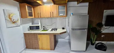 a small kitchen with a microwave and a refrigerator at Coco house by Julio 2 in Nagua