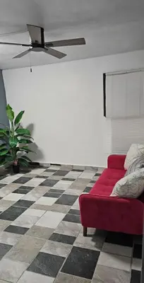 a living room with a red couch on a checkered floor at Coco house by Julio in Nagua