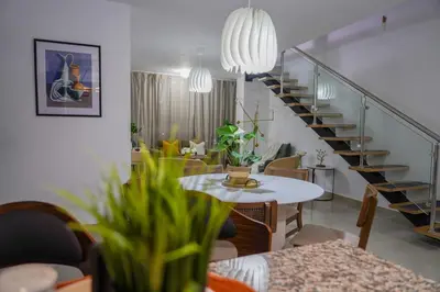 a living room with a table and a staircase at Cozy Loft In The Heart of Santo Domingo Este in Juan López