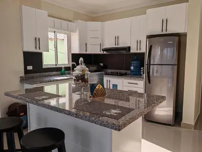 a kitchen with white cabinets and a stainless steel refrigerator at 2 Bdrm, Wi-fi, Hot Water Near Beach and River, 2R in Paraíso
