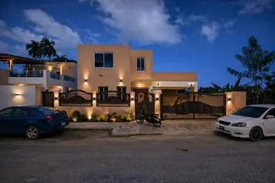 a house with two cars parked in front of it at Private residential vacation home in Cabarete in Cruce de Veragua