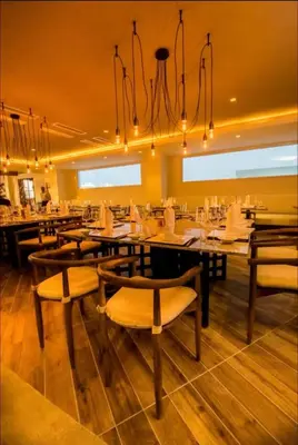 a restaurant with tables and chairs and a chandelier at Imperial Suite 1-bedroom ocean view and kitchen in Cabarete