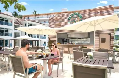 two men sitting at a table on a patio at Imperial Suite 1-bedroom ocean view and kitchen in Cabarete