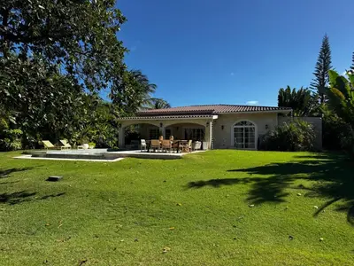 a house with a yard with green grass at Villa Wolf in Punta Cana