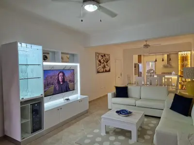 a living room with a couch and a tv at Big & classy condo at Cocotal Golf & Beach in Punta Cana