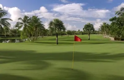a golf course with a red flag on the green at Big & classy condo at Cocotal Golf & Beach in Punta Cana