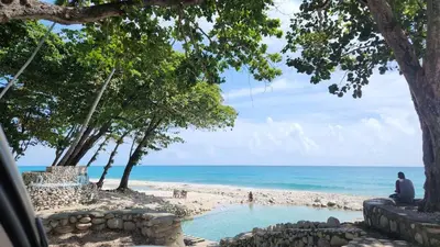 a man sitting on the beach looking at the ocean at 2 Bdrm, 1 Bath, Wifi, Near River and Beach, 3R, Paraiso, Barahona in Paraíso