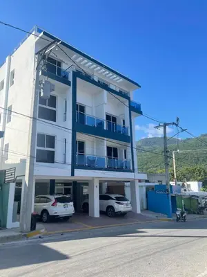 a white building with cars parked in front of it at 2 Bdrm, 1 Bath, Wifi, Near River and Beach, 4R, Paraiso, Barahona in Paraíso