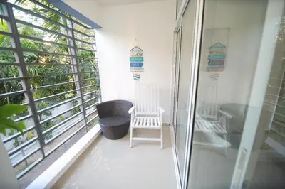 a balcony with two white chairs and a window at franchecis hostal cerca del mar in Juan Dolio