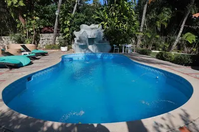 a large blue swimming pool with a fountain at Horizonte Marino En De Franchecis Hostal in Juan Dolio