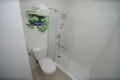 a white bathroom with a toilet and a shower at Horizonte Marino En De Franchecis Hostal in Juan Dolio